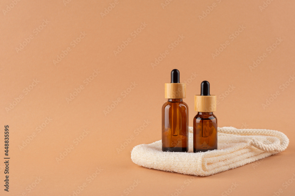 Eco friendly washcloth with amber glass dropper bottles. Zero waste and plastic free concept on beige background. Skincare natural cosmetic concept for face body care