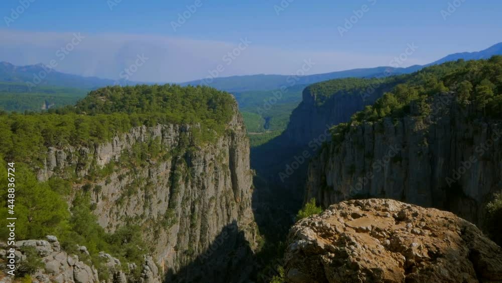 Sheer cliffs of the canyon among the green forest.A view of the beautiful majestic mountains. A view of the wild forest and mountain range. Sheer cliffs of the canyon among the green forest.A view of the beautiful majestic mountains. A view of the wild forest and mountain range.