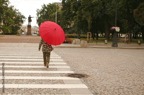 young girl with red umbrella in the city