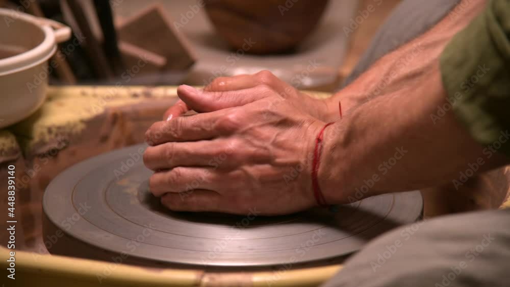 Close-up of a man potter kneading clay beats it for installation on a potter's wheel Close-up of a man potter kneading clay beats it for installation on a potter's wheel