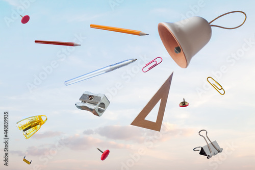 Fotografie Flying school supplies after ring bell blue sky background