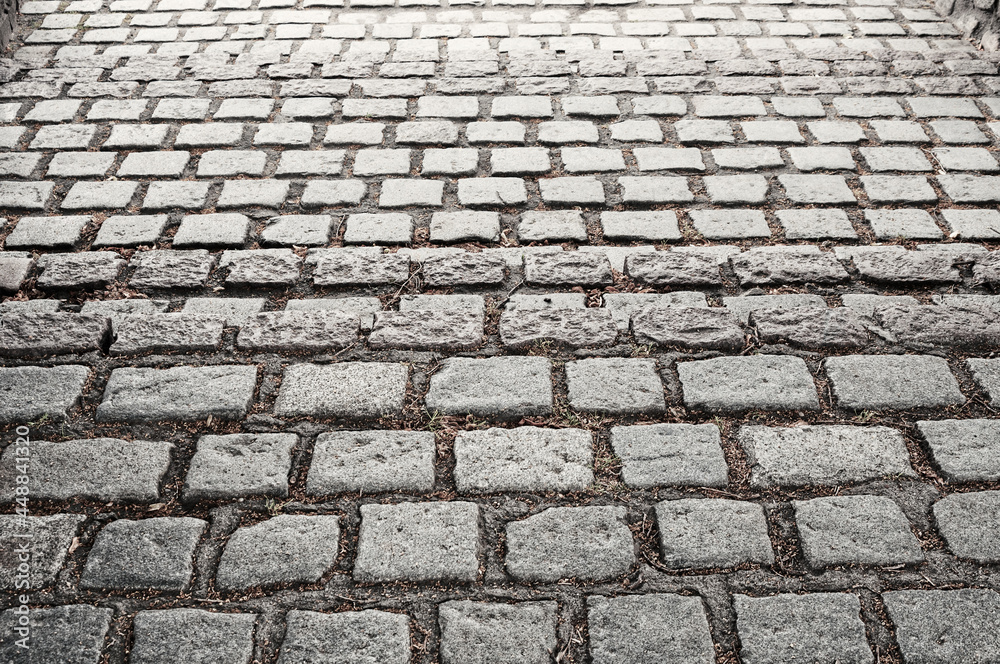 Old gray cobblestone pavement as background