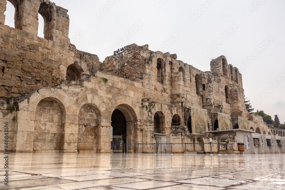 Athens, Greece - September 24, 2019: Entrance square to Odeon of Herodes Atticus with marble flooring on hills of Acropolis. Ancient architecture on rainy cloudy day