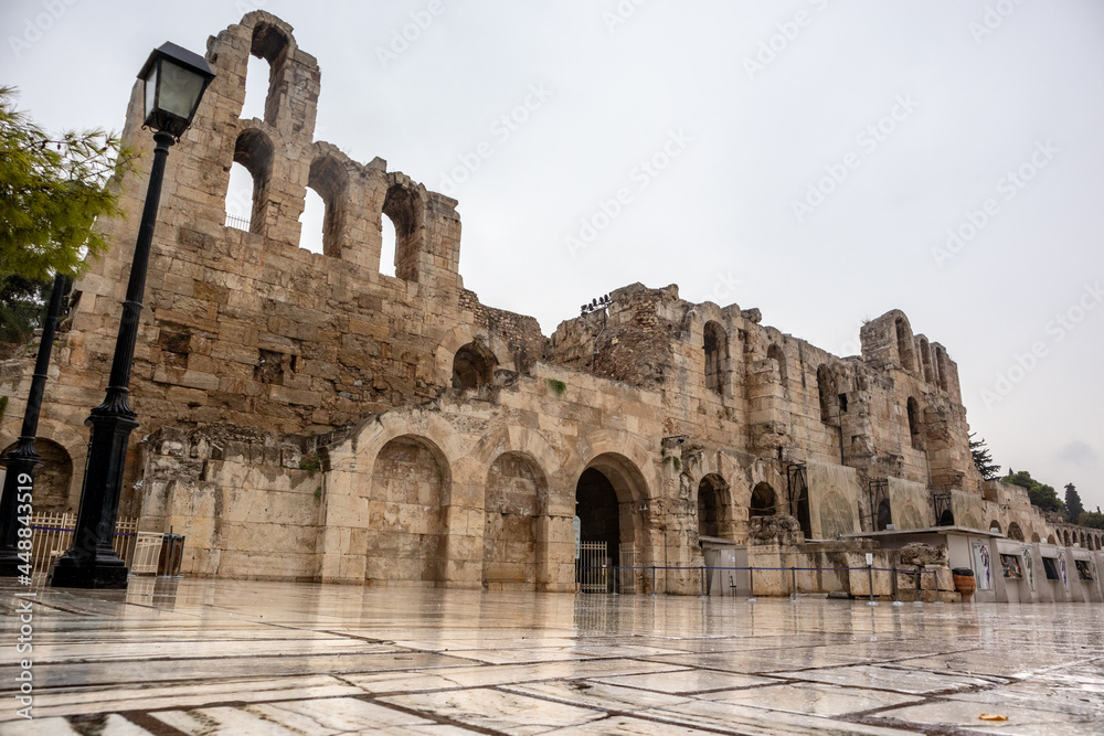 Athens, Greece - September 24, 2019: Entrance marble square to Odeon of Herodes Atticus on hills of Acropolis. Ancient architecture on rainy cloudy day