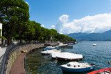 View over the beautiful, gorgeous lake Como seen from the village of Lenno. It is a beautiful sunny summer day, with blue sky and a few clouds. There are boats on the lake