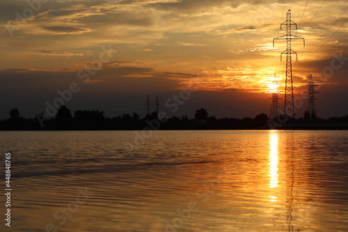 sunset on the lake shore. Natural landscape. Reflection, blue sky and yellow sunlight. Landscape during sunset.