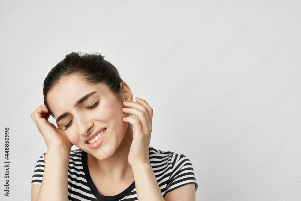 brunette in striped t-shirt holding face toothache discontent health problem brunette in striped t-shirt holding face toothache discontent health problem