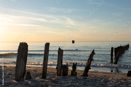 Old wooden breakwater on the beach during sunset. Mielno  Poland. Selective focus. 