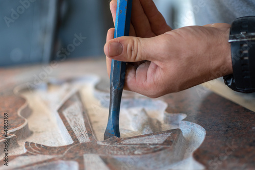 Photo caucasian man hands bushhammered a tombstone in a workshop, work concept