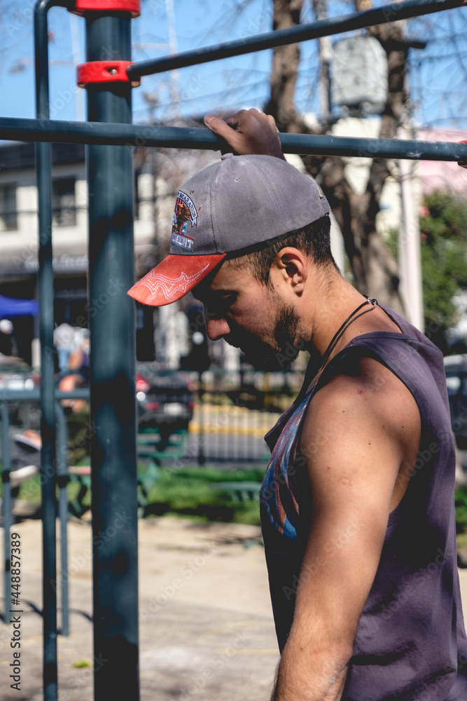 Fit and handsome athlete guy doing stretching in an street workout park with bars in a sunny day of summer Fit and handsome athlete guy doing stretching in an street workout park with bars in a sunny day of summer