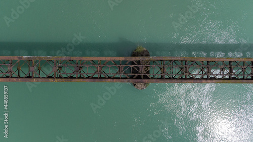 Old deserted and dangerous railway bridge in Dravograd, once important transit path, now forgotten above the Drava river. View from above photo