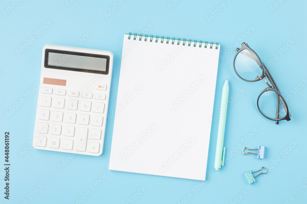 Office desk with calculator, notepad and glasses. Office desk with calculator, notepad and glasses.