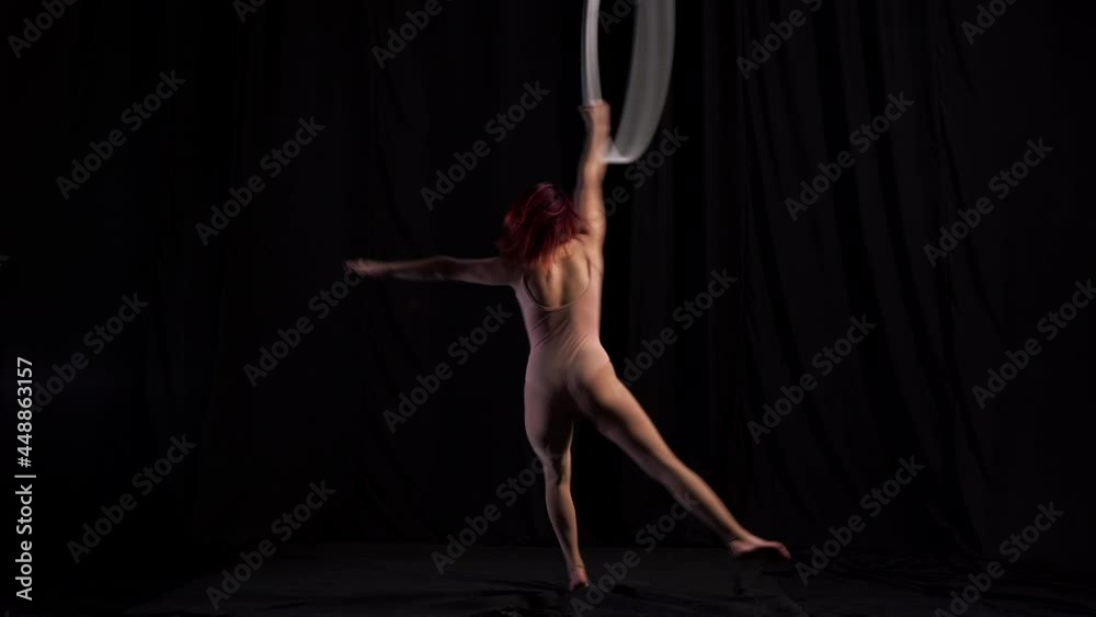 Young girl in a beige leotard performs a sensual dance on an air ring. circus artist, graceful aerialist Young girl in a beige leotard performs a sensual dance on an air ring. circus artist, graceful aerialist