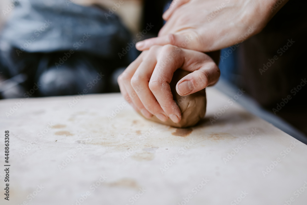 Ceramist mashing clay in workshop 