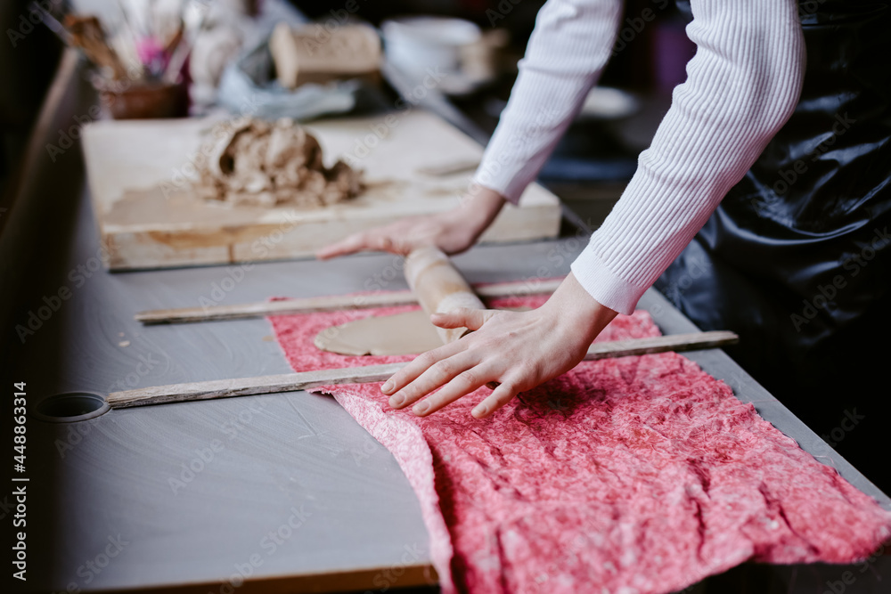 Artist unrolling clay on desk Artist unrolling clay on desk