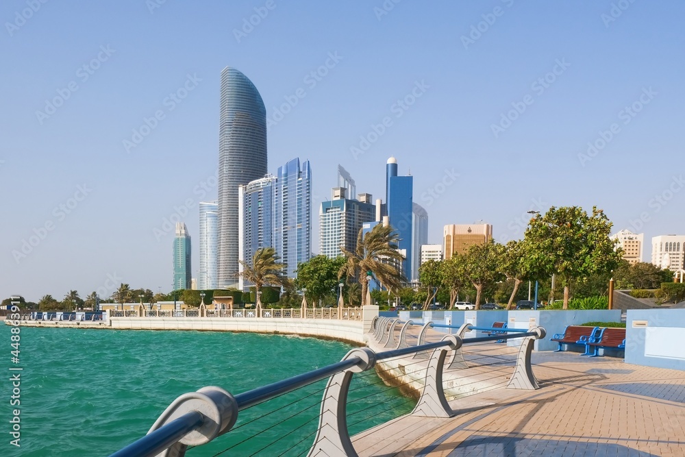 Abu Dhabi promenade with view to modern skyscrapers of downtown and cozy walking area.United Arab Emirates
