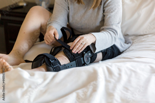 Woman's hands attaching strap on leg brace