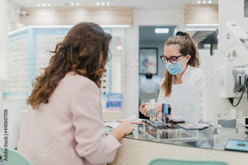 Woman wearing face mask shopping for glasses