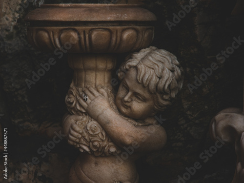 Fotografie Closeup of a cherubim sculpture holding a birdbath
