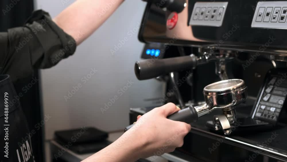 Girl remove the coffee holder from the coffee machine and wipe it Girl remove the coffee holder from the coffee machine and wipe it