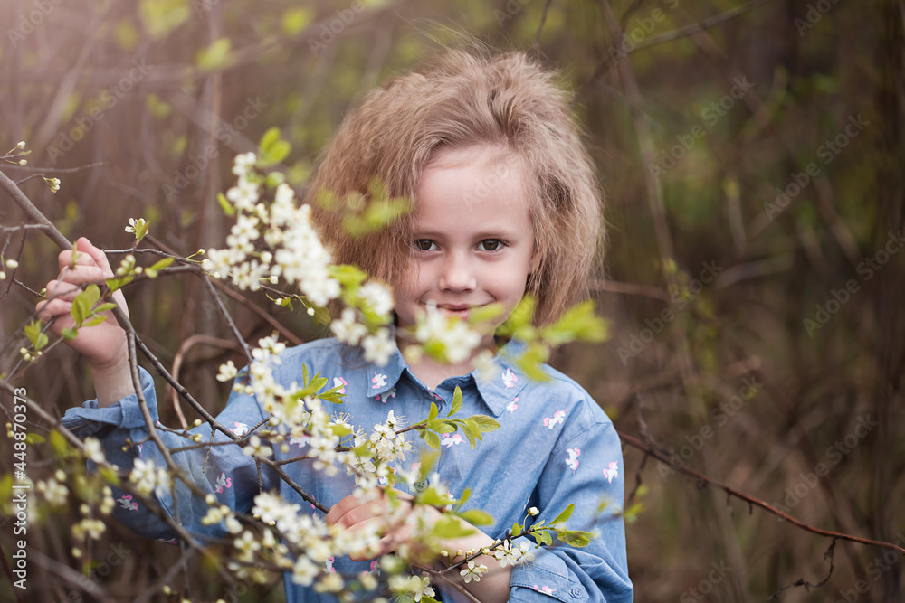 Portrait of little caucasian girl in park standing under blossoming cherry tree Portrait of little caucasian girl in park standing under blossoming cherry tree