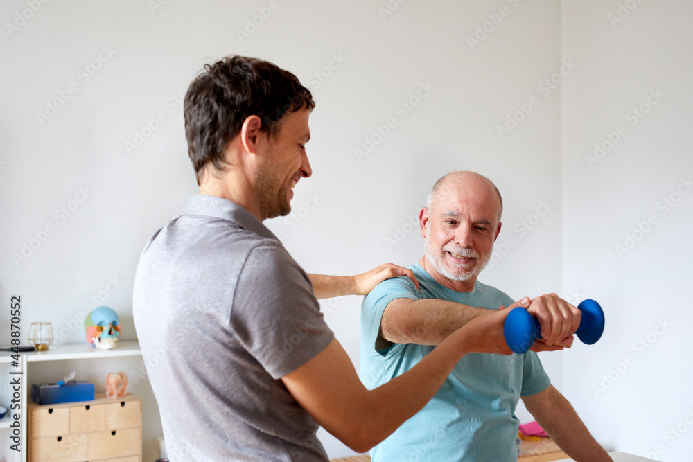 An osteopath correcting patient's exercise An osteopath correcting patient's exercise