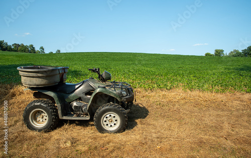 Off road vehicle atv alongside lush green soybean field photo