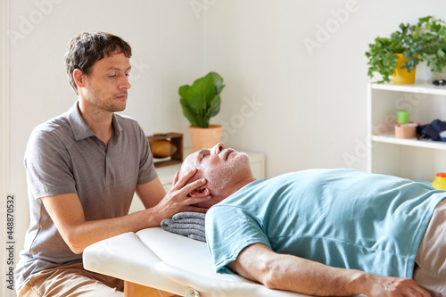 An osteopath applying pressure to patient's head