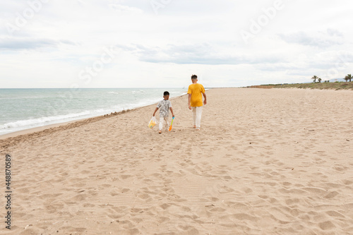Little siblings walking together near the sea photo
