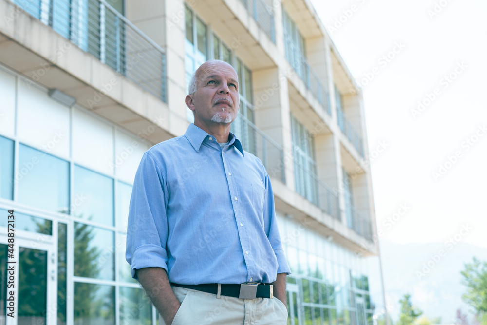 Troubled senior man staring up in angst at the sky