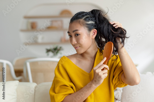 asian woman using a hairbrush photo