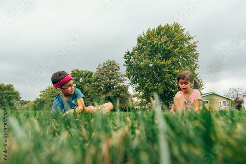 Children sitting in tall grass. 