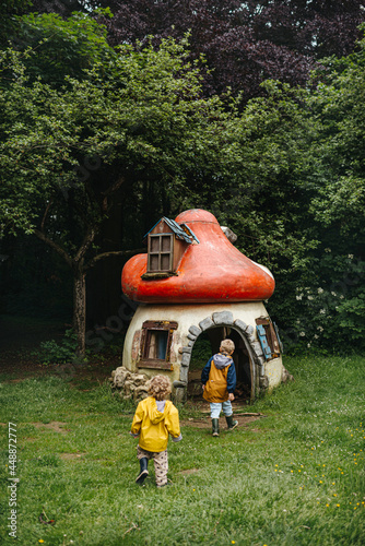 Siblings in a garden with gnome house photo