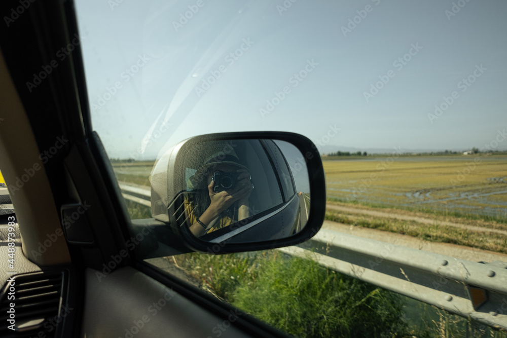 Reflection of a woman in the rear view mirror of the car Reflection of a woman in the rear view mirror of the car