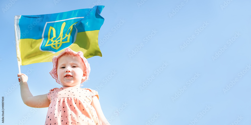 girl holding flag of Ukraine. Blue yellow flag of Ukraine with coat of arms in hands of child on Independence Day and Flag Day. girl holding flag of Ukraine. Blue yellow flag of Ukraine with coat of arms in hands of child on Independence Day and Flag Day.