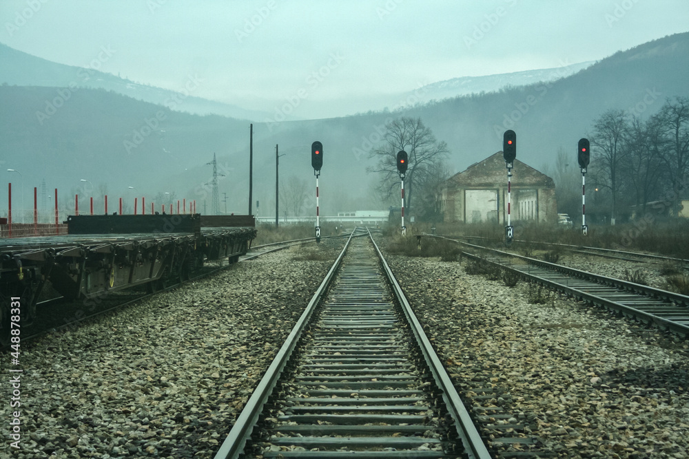 Fototapeta premium Red lights on a railway signals in the abandoned railway station of Kosovska Mitrovica, or Mitrovice, in Kosovo, at the border between the Albanian and the Serbian part of the city, divided...
