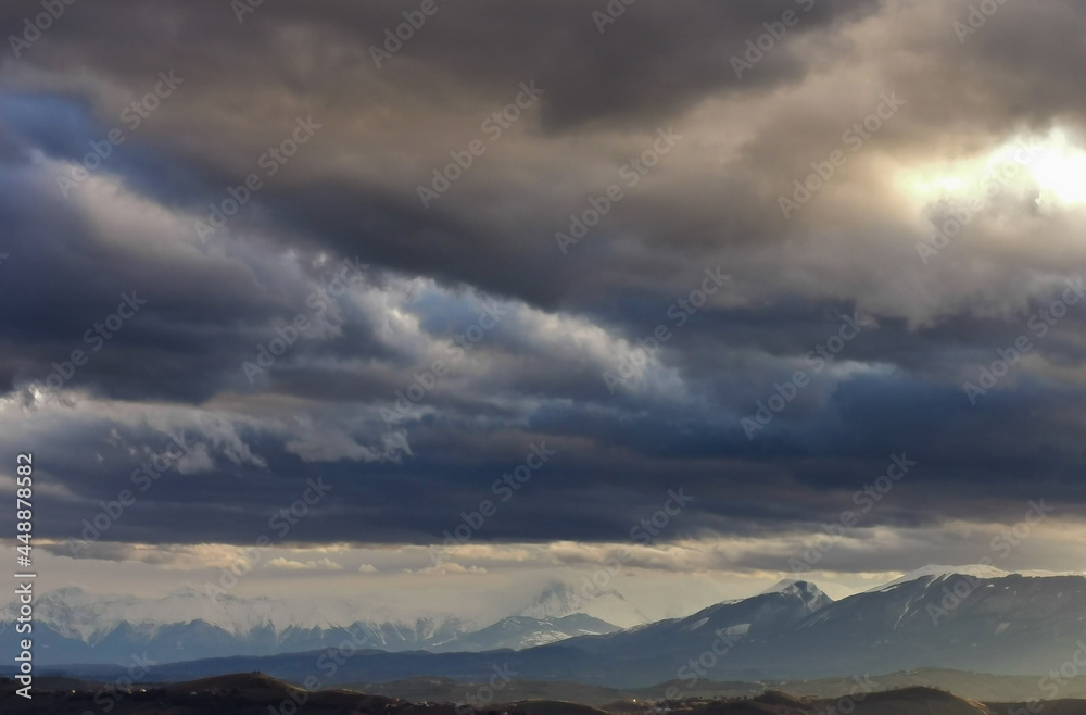 Enormi nuvole grigio azzurre sopra le montagne e le valli dell’Appennino
