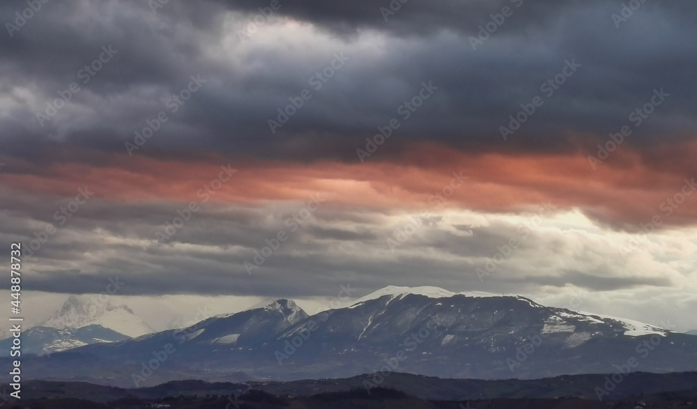 Nuvole rosse sopra le cime innevate dei monti Appennini Nuvole rosse sopra le cime innevate dei monti Appennini