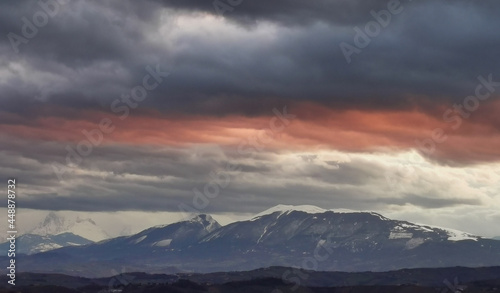 Nuvole rosse sopra le cime innevate dei monti Appennini