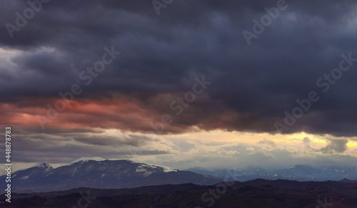 Nuvole rosse sopra le cime innevate dei monti Appennini