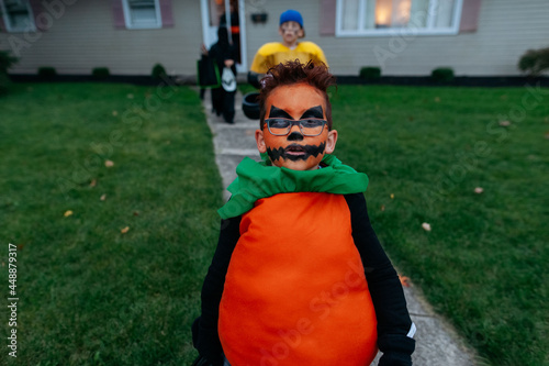 Trick-or-treaters leaving a house after getting candy.  photo