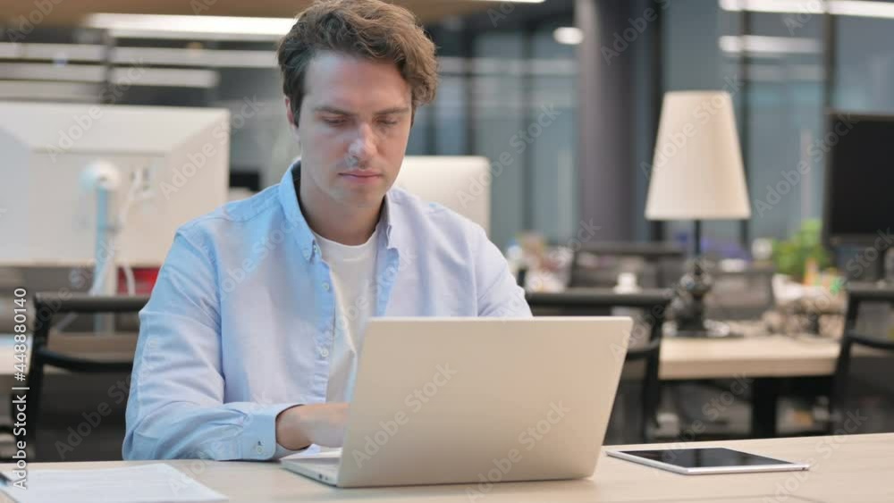 Man Shaking Head as No Sign while using Laptop in Office Man Shaking Head as No Sign while using Laptop in Office