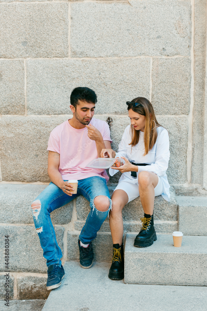 Young couple eating some street food Young couple eating some street food