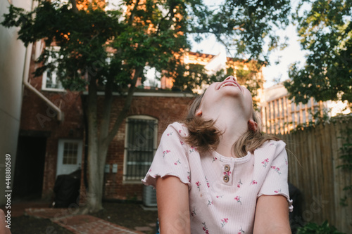 Young Girl Throws Her Head Back and Laughs photo