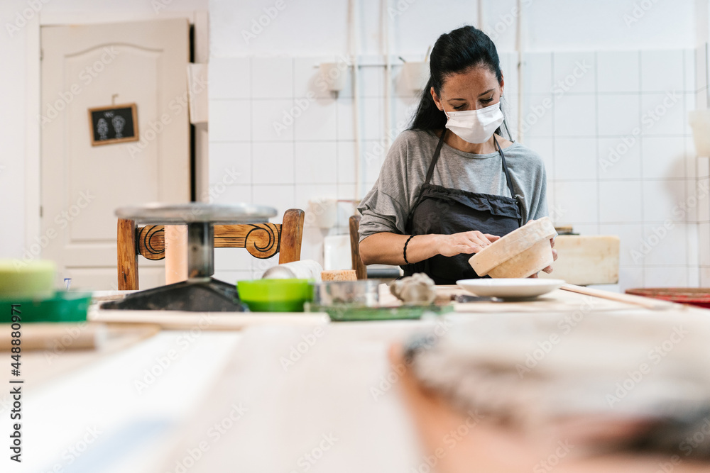 Woman at counter in clay pottery Woman at counter in clay pottery