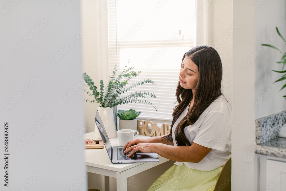 Hispanic freelancer using laptop at home Hispanic freelancer using laptop at home