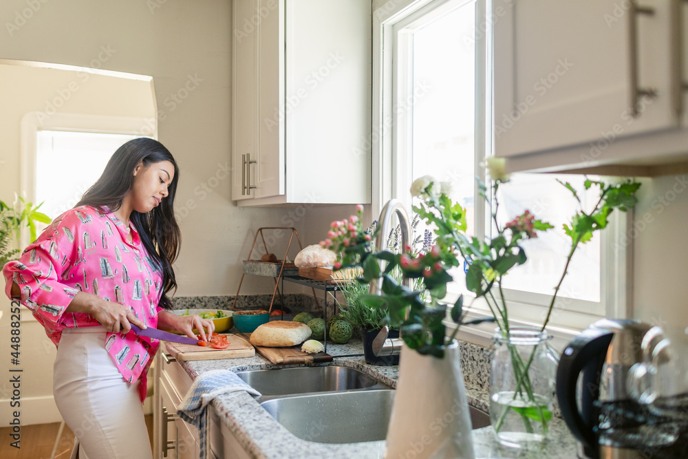 Young woman preparing sandwich with tomatoes at home Young woman preparing sandwich with tomatoes at home
