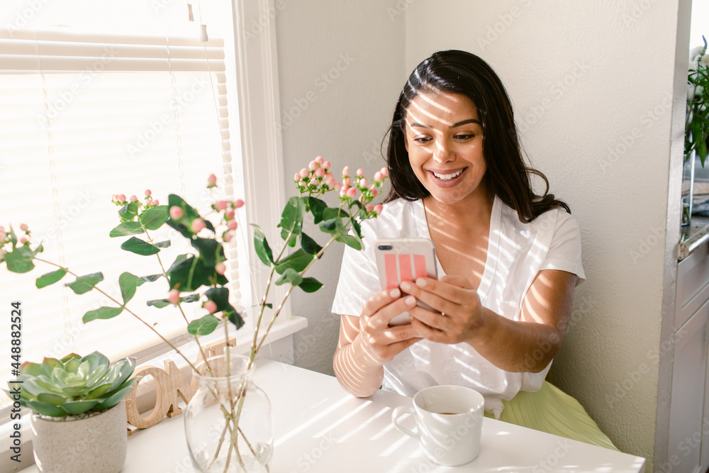 Happy Hispanic woman using smartphone in morning Happy Hispanic woman using smartphone in morning
