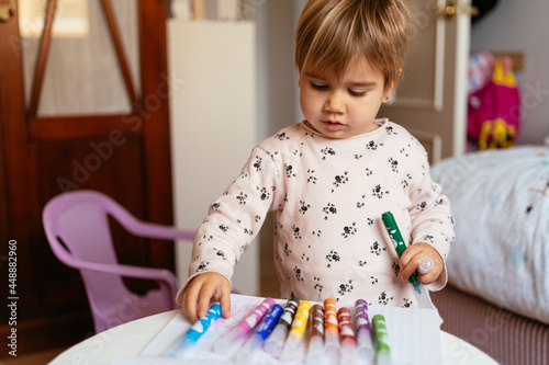 A Kid Playing with Some Pencils photo