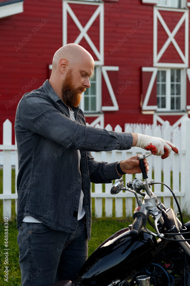 Bearded guy repairing motorcycle handlebar Bearded guy repairing motorcycle handlebar